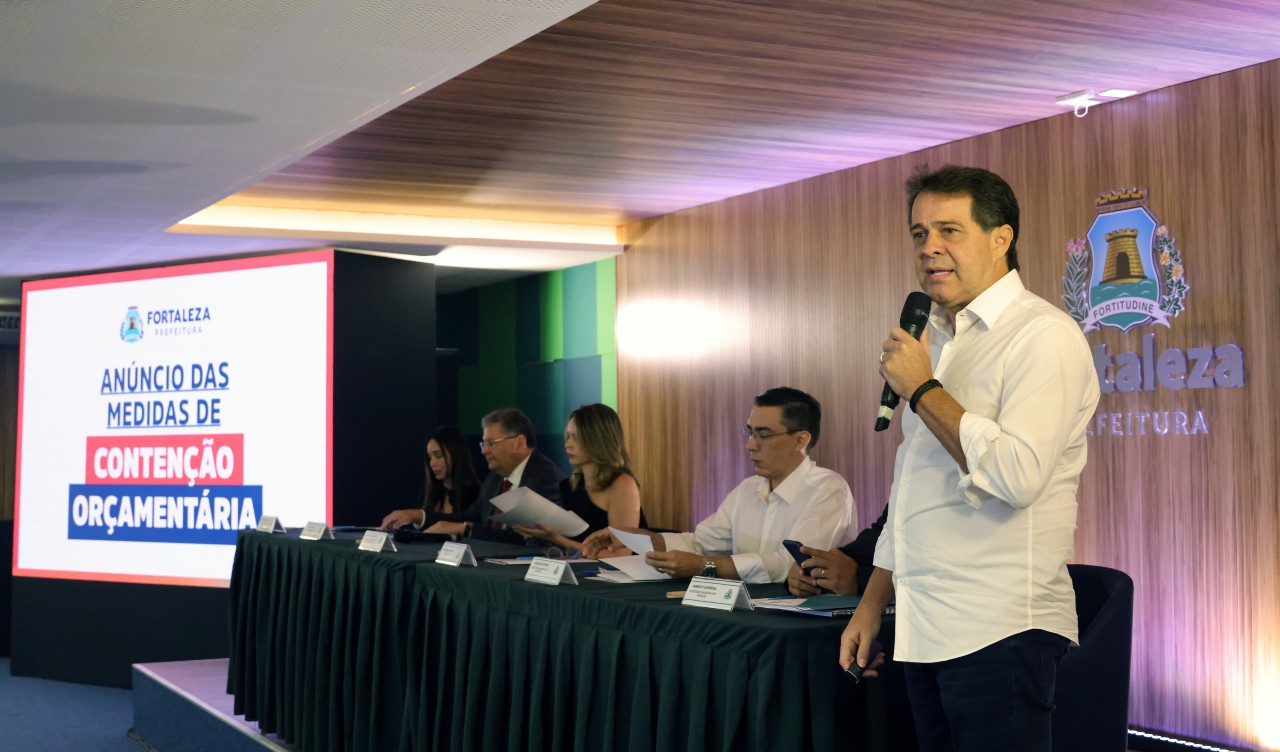 prefeito evandro fala ao microfone no auditório